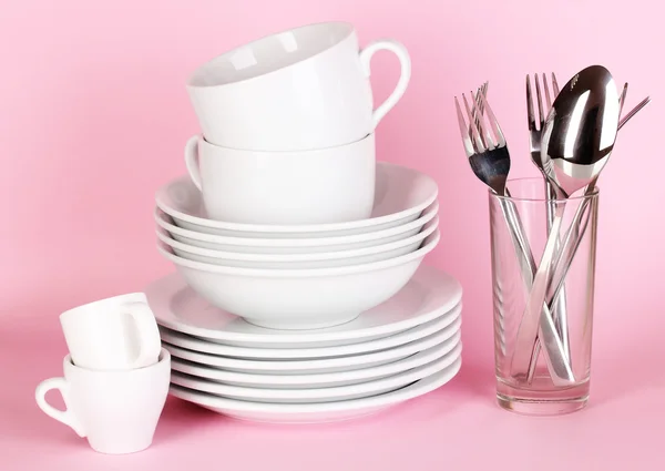 Clean white dishes on pink background — Stock Photo, Image