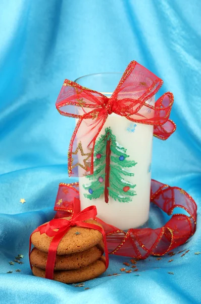 Cookies for Santa: Conceptual image of ginger cookies, milk and christmas decoration on blue background — Stock Photo, Image