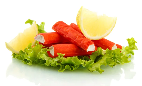 Palitos de cangrejo sobre hojas de lechuga con limón, aislados sobre blanco —  Fotos de Stock