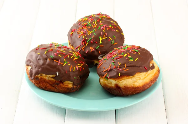 Smakelijke donuts op kleurplaat op lichte houten achtergrond — Stockfoto