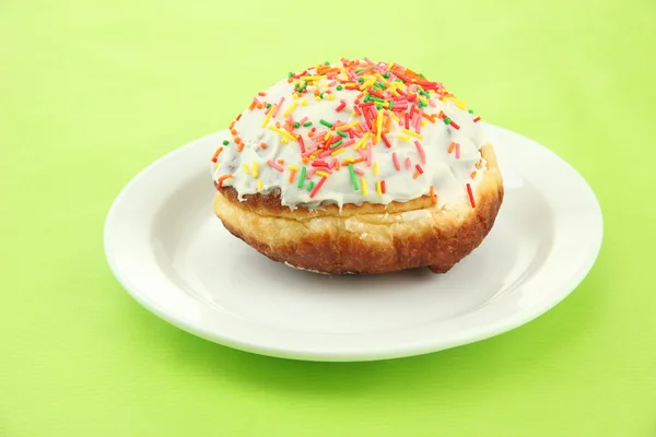 Смачні пончики на кольоровій тарілці на кольоровому фоні — стокове фото