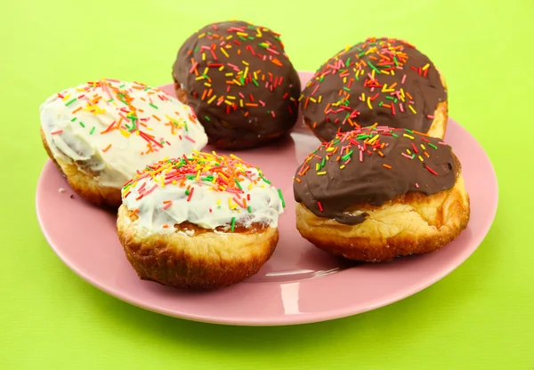 Tasty donuts on color plate on color background — Stock Photo, Image