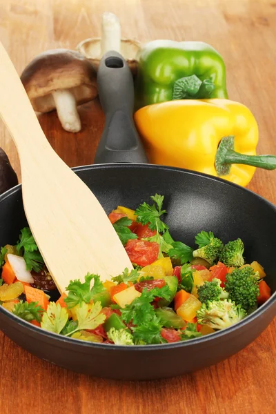 Légumes frais tranchés dans une casserole sur une table en bois — Photo