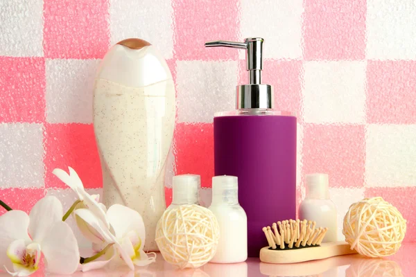 Accesorios de baño en el estante en el baño sobre fondo de pared de baldosas rosa —  Fotos de Stock