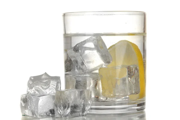 Cubos de hielo en vidrio con limón aislado en blanco — Foto de Stock