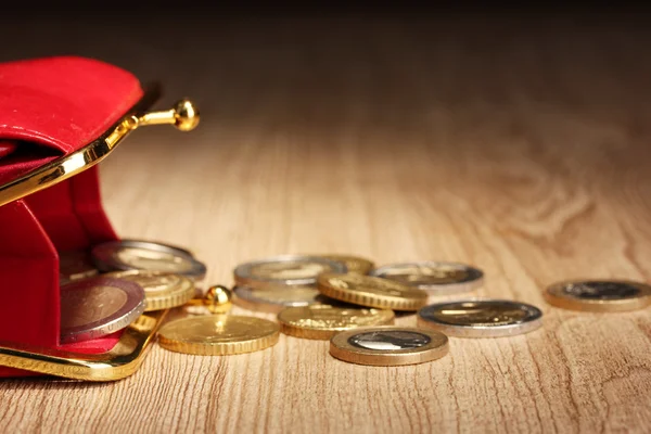 Samice červená peněženka s mincemi na dřevěné pozadí — Stock fotografie
