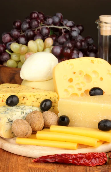 Различные сорта сыра на деревянной доске — стоковое фото
