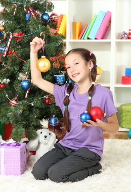 Noel ağacı süsleyen küçük kız