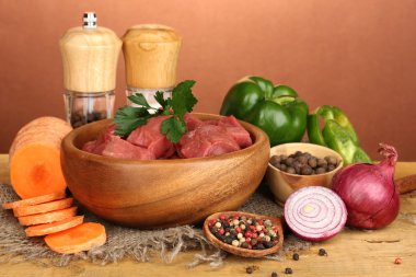 otlar ve baharatlar kahverengi zemin üzerine ahşap masa üzerinde marine edilmiş ham sığır eti