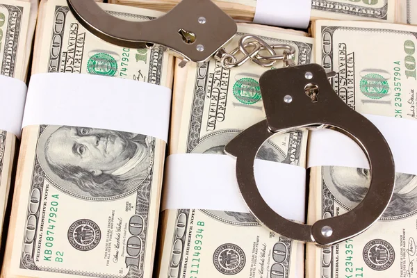 Handcuffs on the packs of dollars close-up — Stock Photo, Image