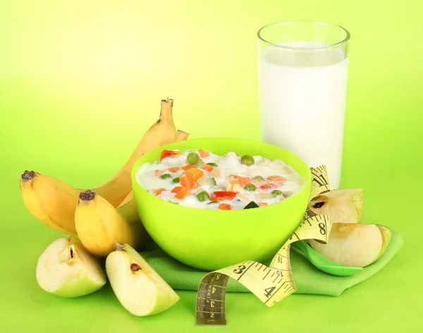 Sabrosos alimentos dietéticos, frutas y vaso de leche, sobre fondo verde —  Fotos de Stock