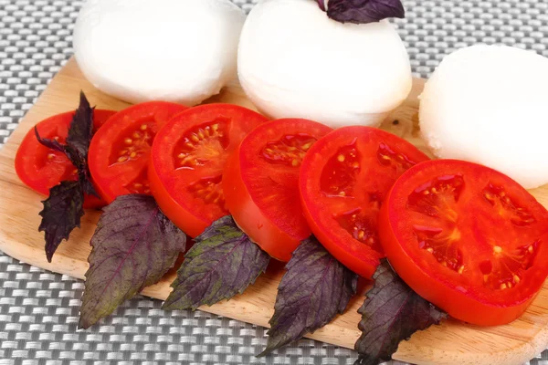 Mozzarella saporita con pomodori sul tagliere primo piano — Foto Stock