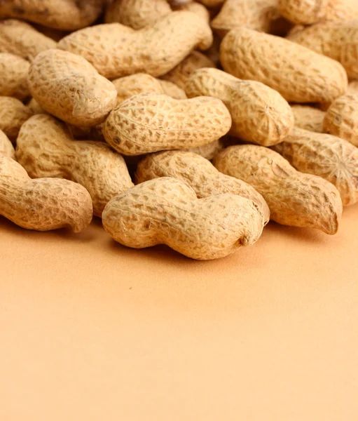 Välsmakande jordnötter, på beige bakgrund — Stockfoto