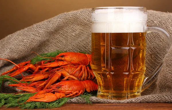 美味的水煮小龙虾和啤酒的棕色背景上的表 — 图库照片