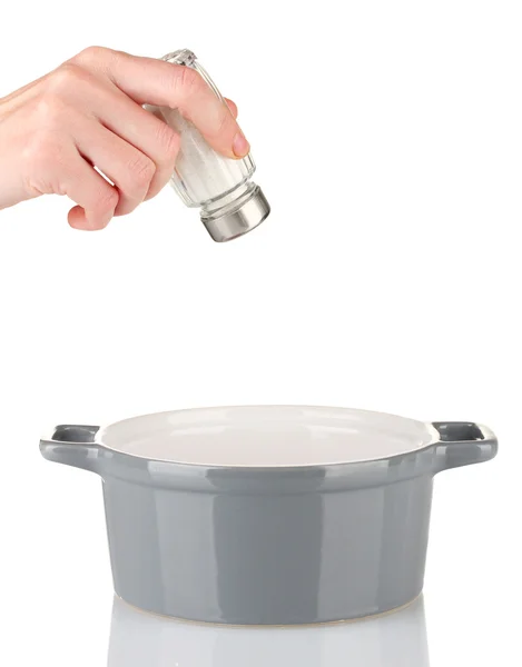 Рука додавання солі за допомогою сольового шейкера ізольовано на білому — стокове фото