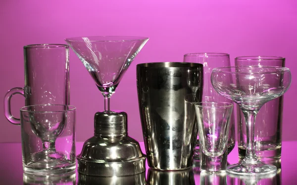 Shaker cocktail e bicchieri su sfondo colore — Foto Stock