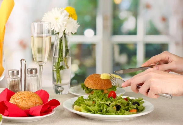 Mano femenina con cena sobre fondo brillante — Foto de Stock