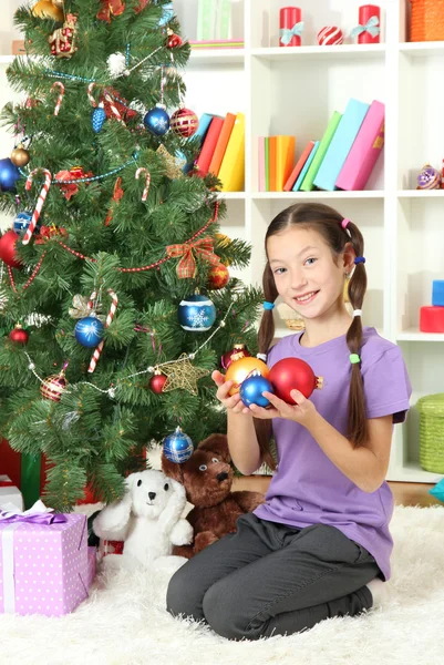Κοριτσάκι στολίζει χριστουγεννιάτικο δέντρο — Φωτογραφία Αρχείου