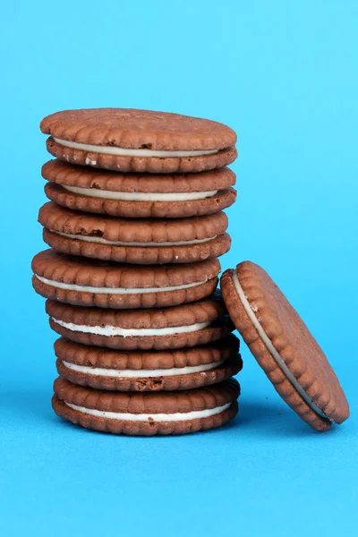 Chocolate cookies with creamy layer on blue background — Stock Photo, Image