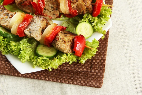 Sabrosa carne a la parrilla y verduras en pincho en el plato, en la mesa — Foto de Stock