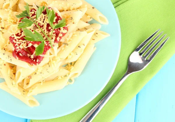 Rigatoni prato de massas com molho de tomate na mesa de madeira azul close-up — Fotografia de Stock