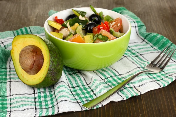 Leckerer Avocadosalat in Schüssel auf Holztisch in Großaufnahme — Stockfoto