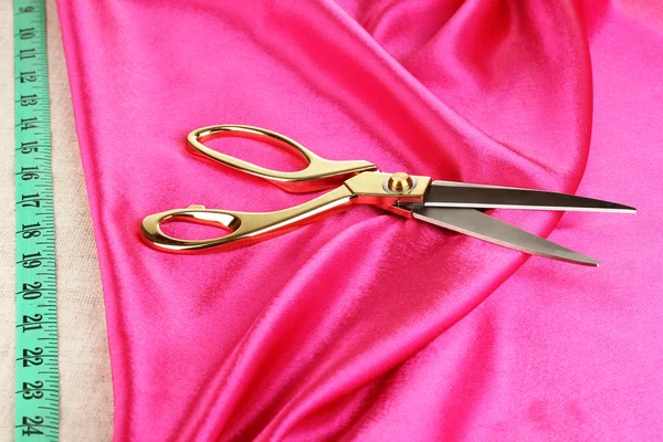 Metal scissors on pink fabric — Stock Photo, Image