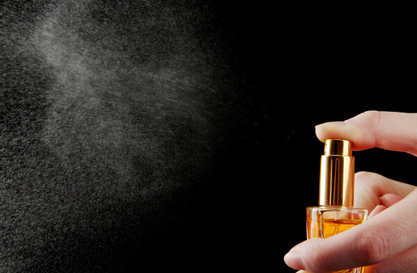 женские духи в бутылке и распыления, на черном фоне
