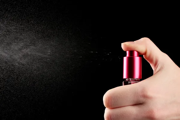 Жіночі парфуми в пляшці та розпилювачі, на чорному фоні — стокове фото