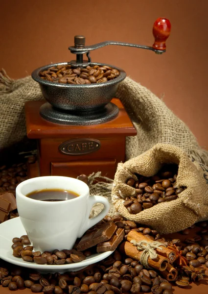 Xícara de café, moedor, turk e grãos de café em fundo marrom — Fotografia de Stock