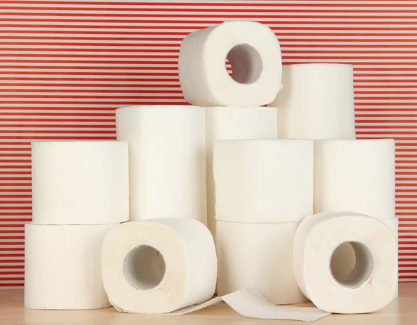 Rollos de papel higiénico sobre fondo rojo rayado — Foto de Stock