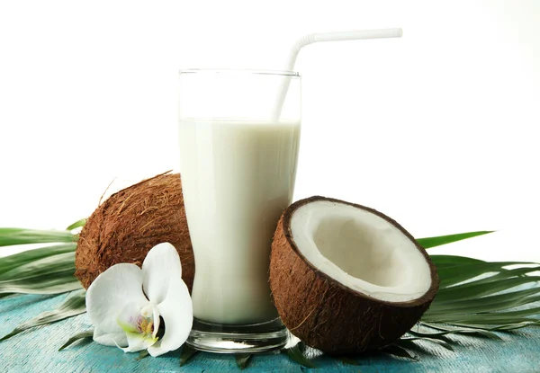 Kokosnoten met glas melk, op blauwe houten achtergrond — Stockfoto