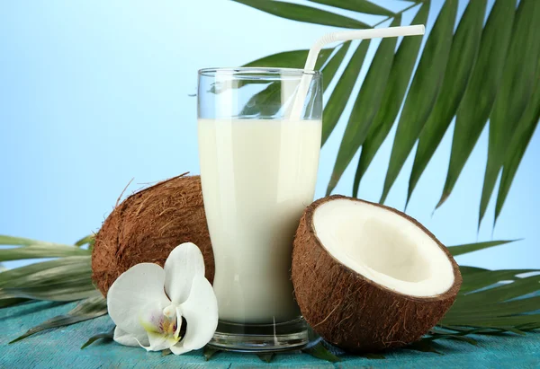 Kokosnüsse mit Glas Milch, auf blauem Hintergrund — Stockfoto