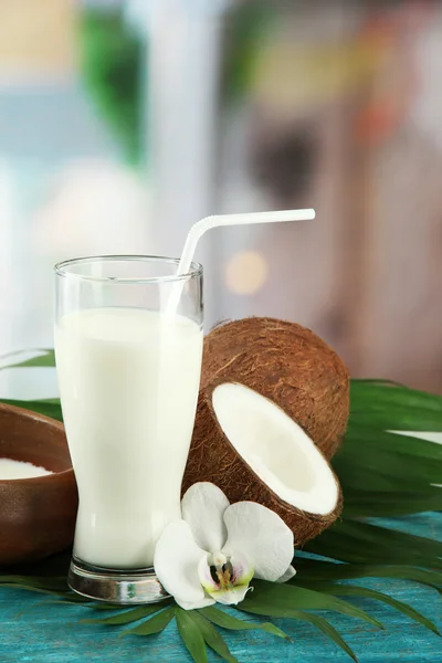 Noce di cocco con vetro di latte, su tavolo di legno blu — Foto Stock