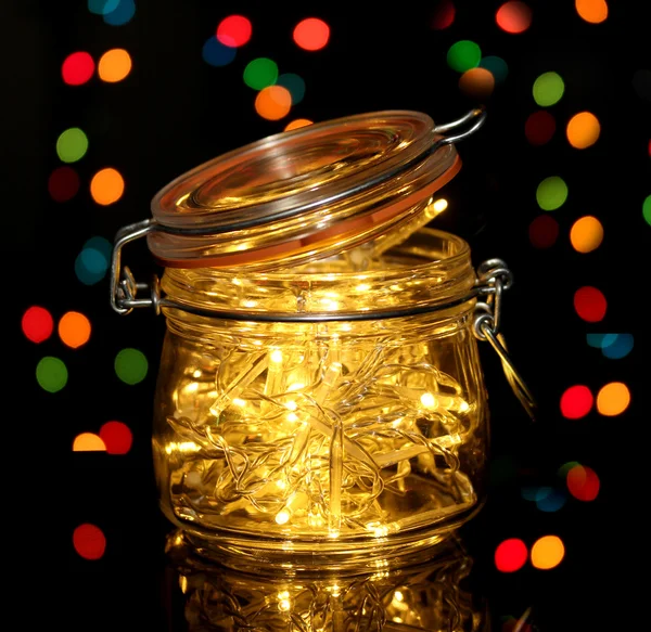 Luces de Navidad en botella de vidrio sobre fondo de luces borrosas —  Fotos de Stock