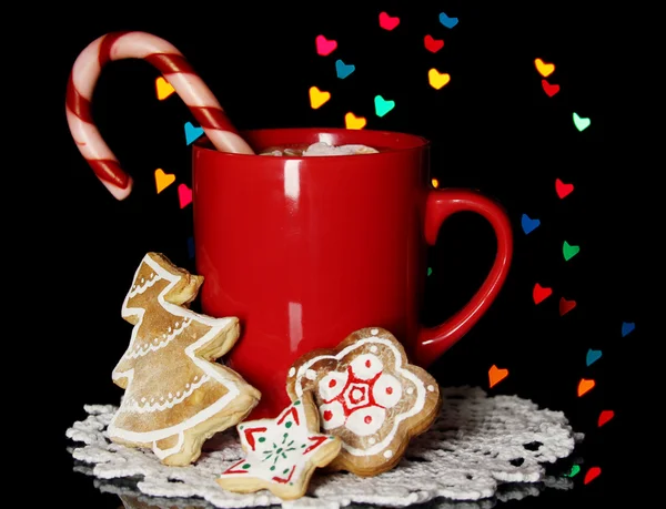 Tasse Kaffee mit Feiertagsbonbons auf Weihnachtsbeleuchtung Hintergrund — Stockfoto