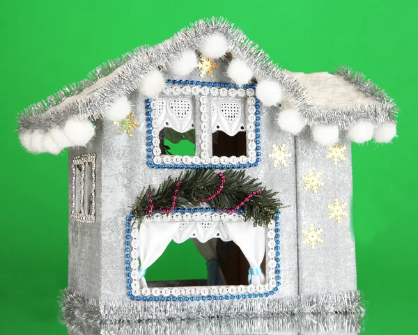 Urządzony domek bożonarodzeniowy na zielonym tle — Zdjęcie stockowe