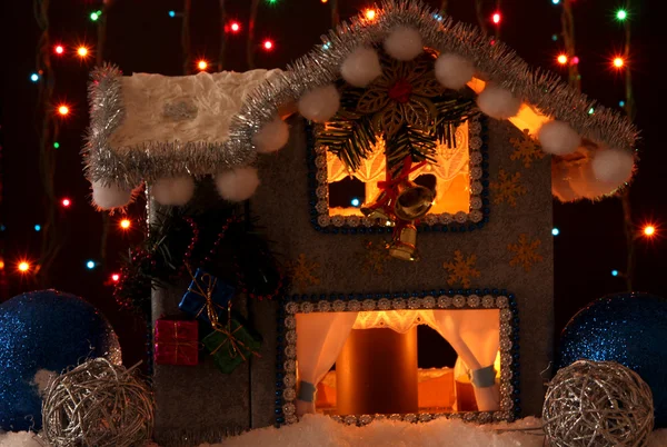 Casa de Natal decorada com luzes no fundo escuro — Fotografia de Stock