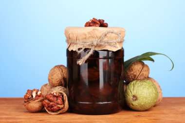 Ceviz ahşap masa mavi zemin üzerine üzerine reçel kavanoz