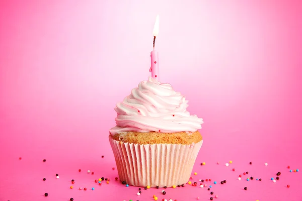 Välsmakande födelsedag cupcake med ljus, på rosa bakgrund — Stockfoto