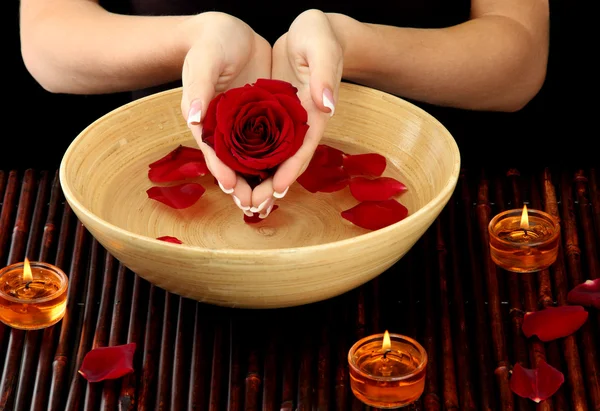 Woman hands with wooden bowl of water with petals — Stock Photo, Image