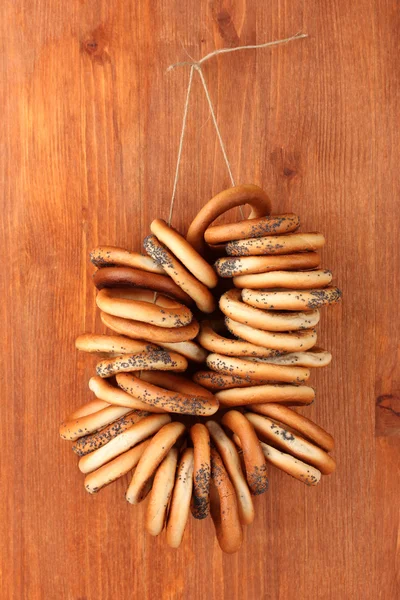 Bagels saborosos na corda, no fundo de madeira — Fotografia de Stock