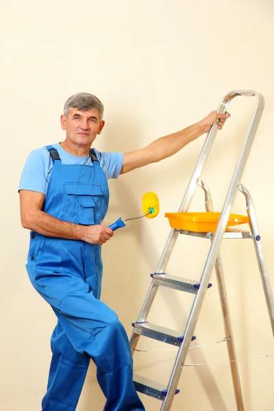 Pintor masculino pinta parede no quarto close-up — Fotografia de Stock