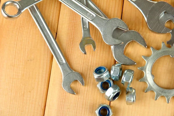 Engrenages de machines, roues dentées métalliques, écrous et boulons sur fond bois — Photo