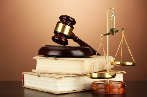 Golden scales of justice, gavel and books on brown background — Stock Photo, Image