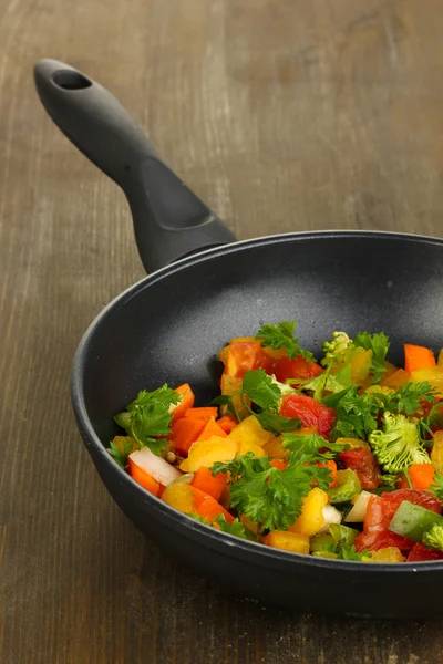 Verdure fresche affettate in padella sul tavolo di legno — Foto Stock