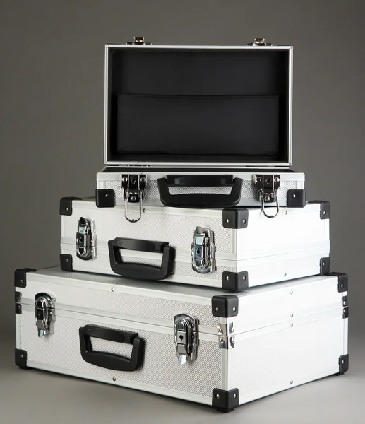 Silvery suitcases on grey background — Stock Photo, Image