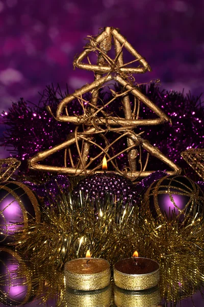 Χριστούγεννα σύνθεσης με κεριά και διακοσμήσεις σε πορφυρά και χρυσά χρώματα σε φωτεινό φόντο — Φωτογραφία Αρχείου