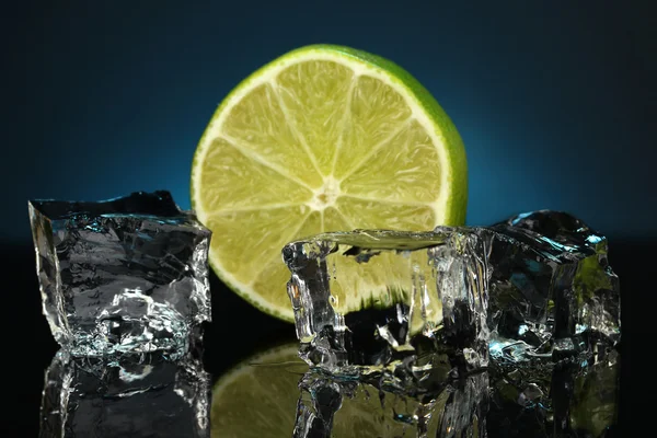 Ice cubes with lime on darck blue background — Stock Photo, Image