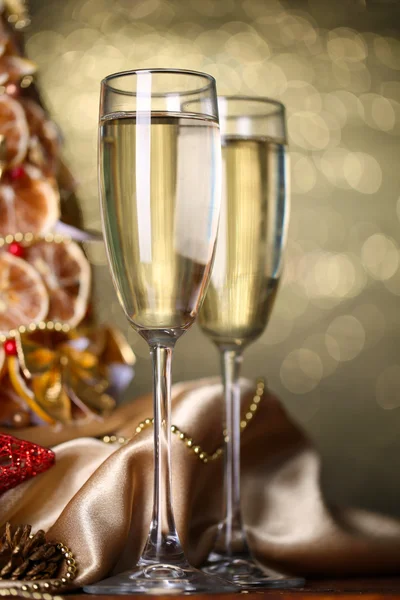 漂亮的圣诞树和香槟在擦眼镜的灰色背景 — 图库照片